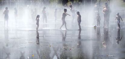 Un grupo de ni&ntilde;os se refresa en la &#039;playa&#039; de Madrid R&iacute;o.