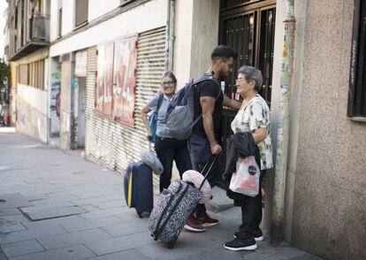 Tres personas llegando a un piso de alquiler turístico.