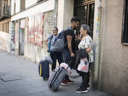 Tres personas llegando a un piso de alquiler turístico.