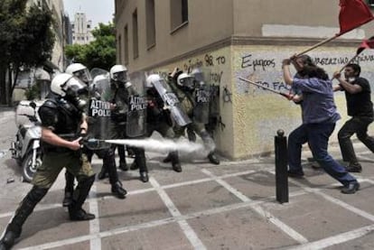 Policías antidisturbios lanzan gas lacrimógeno contra un grupo de manifestantes en el centro de Atenas.
