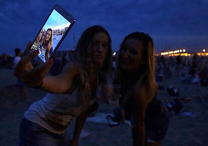 Unas jóvenes se hacen un selfie en la playa de La Malvarrosa en Valencia durante la noche de San Juan.