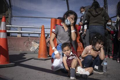 Vilma Iris Peraza y sus hijos Erick y Adriana, de Honduras, lloran sobre el Puente Internacional de Ciudad Juárez al ser expulsados de Estados Unidos a México junto con otras 100 familias de migrantes, el 17 de marzo de 2021.