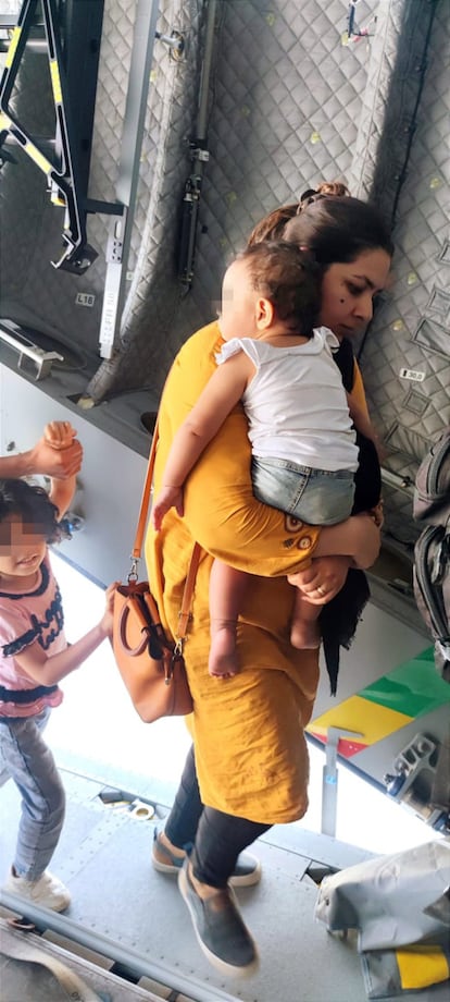 Una mujer con un niño en brazos sube al avión, este viernes en Kabul.