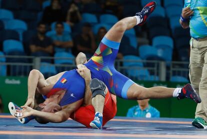 El ruso Islam-Beka Albiev (rojo) lucha contra el rumano Ion Iulian Panait en la categoría masculina de 66 kg de lucha grecorromana.