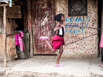 Dos niñas juegan en las calles de Kibera, uno de los mayores y paupérrimos asentamientos de chabolas alrededor de Nairobi, capital de Kenia.