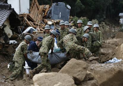 Las fuerzas de defensa japonesas y agentes de la policía transportan el cuerpo de una víctima.