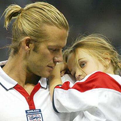 Beckham, con una niña en brazos antes del partido de ayer contra Liechtenstein en Old Trafford.