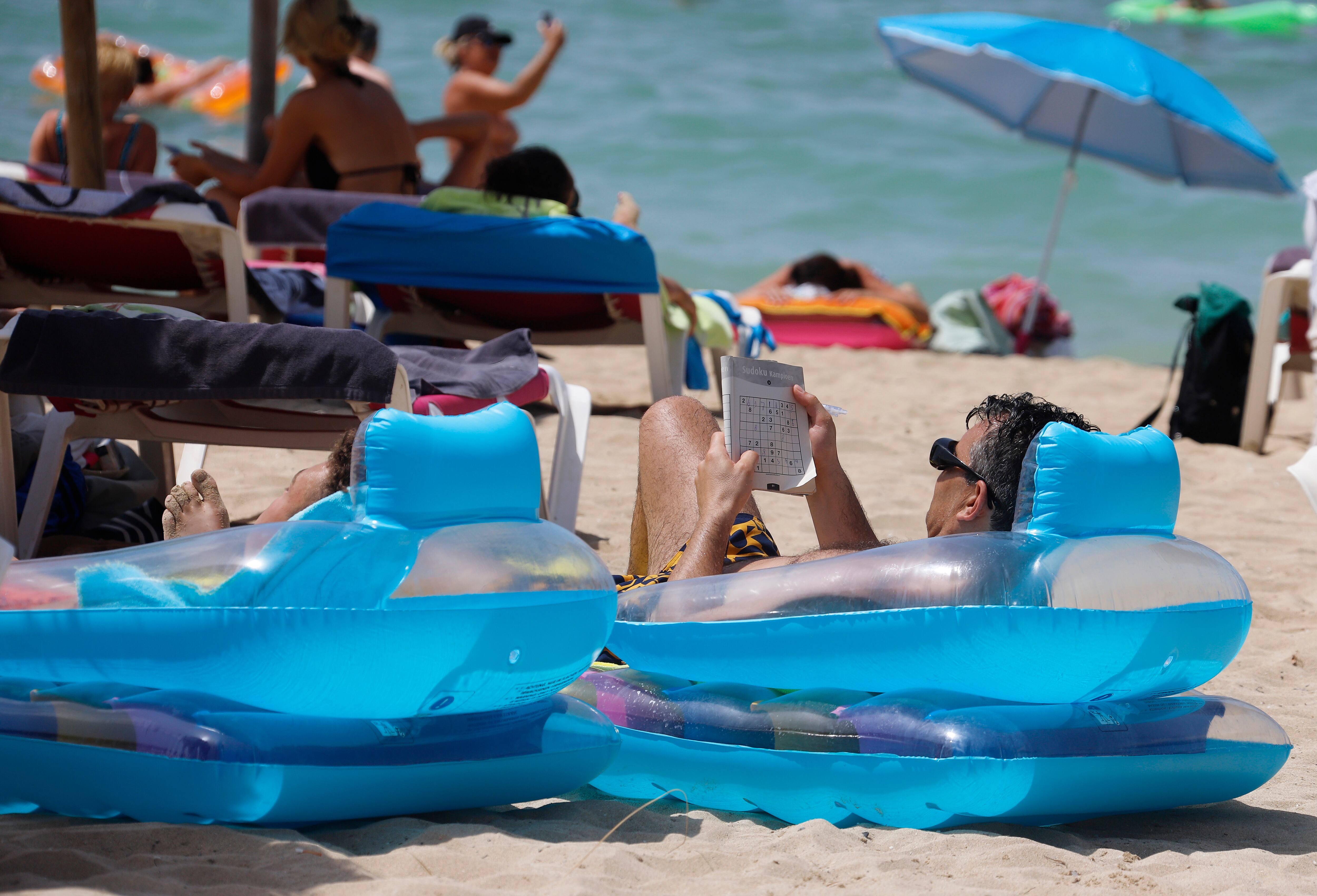 Un hombre leía en una playa de Mallorca, en agosto de 2019.