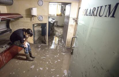 Una joven descansa durante las labores de limpieza y evacuación de agua del solarium de un hotel en Schuettdorf, Austria, 3 de junio de 2013. Las inundaciones causadas por las fuertes lluvias caídas en el centro de Europa se extienden hacia Viena y el este de Austria, donde se ha activado el estado de alerta civil, después de anegar numerosas regiones del oeste del país.