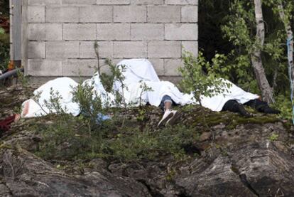 Varios cadáveres cubiertos por sábanas, ayer en la isla de Utoya.