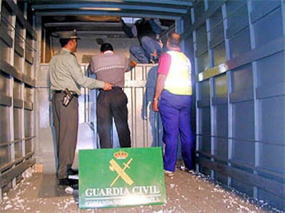 Varios inmigrantes ilegales salen del doble fondo practicado en la parte posterior de la caja del furgón.