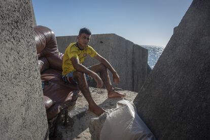 Hamed, de 21 años, lleva casi un mes cobijándose entre los bloques de hormigón de una escollera cercana al puerto. Entró el pasado 17 de mayo a Ceuta. Antes, intentó llegar a la Península embarcando en una lancha neumática, para lo que ahorró unos 2.000 euros gracias a familiares y amigos.