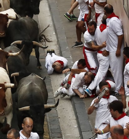 Un grupo de corredores evitan a varios toros de la ganadería abulense de José Escolar durante el segundo encierro de los Sanfermines 2017.