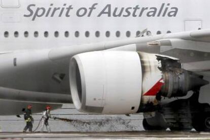Los bomberos se acercan a la turbina dañada del Airbus 380 de Qantas en el aeropuerto de Singapur.