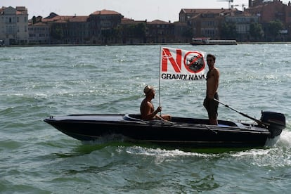 Homens viajam em um barco com o banner 'No Grande Navi' durante uma manifestação contra os grandes cruzeiros que navegam na lagoa de Veneza, em 8 de junho de 2019.