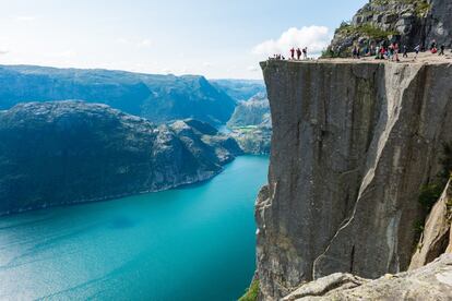 Los suelos de vidrio sobre el vacío y los rascacielos vertiginosos suelen impresionar, pero una de las mejores panorámicas de Noruega se obtiene desde un enorme trampolín de roca. El Preikestolen se asoma desafiante a 604 metros de altura sobre el fiordo de Lyse, en la región de Stavanger (<a href="https://www.regionstavanger-ryfylke.com/" target="_blank">regionstavanger-ryfylke.com</a>), en la accidentada costa oeste del país. En un entorno muy montañoso, esta proa pétrea destaca como una atalaya natural, como una formidable terraza sobresaliendo por encima del agua. Las vistas son tan amplias como vertiginosas, y acongojan más aún si reparamos en las grietas que recorren su plana superficie, resultado de 10.000 años de erosión glacial. La plataforma se ha convertido en uno de los grandes reclamos turísticos de Noruega y en una foto imprescindible en el Instagram de cualquier viajero. Desde la carretera de acceso hasta El Púlpito hay dos horas de caminata, y la mejor época para subir es de abril a septiembre.