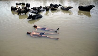 Un par de niños indios se refrescan en el río Tawi, a las afueras de Jammu, capital de invierno de Cachemira (India). Según varios medios, la India sufre una ola de calor abrasador con temperaturas que superan los 40 grados en gran parte del país.