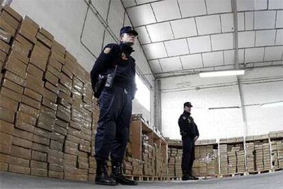 Dos agentes antidisturbios vigilan el hachís decomisado en una nave industrial del polígono industrial La Poveda, en Arganda del Rey.