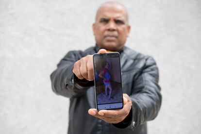 Octavio Pineda , padre de Cris Mairi, posa con una foto de su difunta hija en su teléfono en el madrileño barrio de San Cristóbal de los Ángeles.
