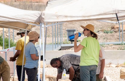 Un grupo de arqueólogos se protegen a mediodía del sol en Jaén, con sombreros, toldos para el trabajo y agua.