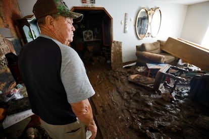 Charles English inspecciona los daños de su sala por el paso del huracán. 