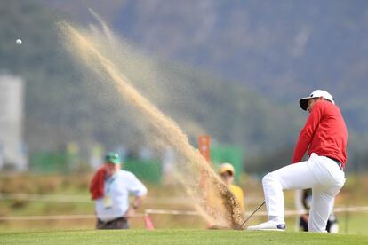 El francés Julien Quesne dispara desde el búnker en la prueba individual de golf. 