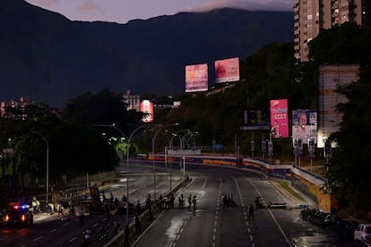 La Policía Municipal de Baruta retira una barricada mientras la gente protesta por los resultados electorales que otorgaron al presidente, Nicolás Maduro, un tercer mandato.