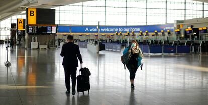 Una viajera transita con máscara por una de las terminales vacías del aeropuerto de Heathrow.