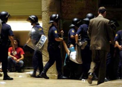 Agentes de la policía sacan a uno de los <i>okupas</i> que tomaron La Pedrera, en Barcelona.