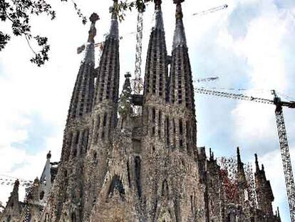 Turistas después de bajar de un autocar frente a la fachada del Nacimiento de la Sagrada Família.
