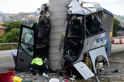 Un Guardia Civil inspecciona los restos del autobús siniestrado. 