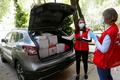 La reina Letizia, junto a los kits de aprovisionamiento que reparte la Cruz Roja, en su visita a una de las sedes de la entidad en Madrid este lunes. 