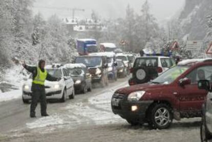Un miembro de la Guardia Civil prohíbe el tráfico en dirección norte a partir de Panticosa, debido al temporal de nieve en la provincia de Huesca. EFE/Archivo