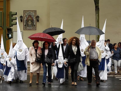 Nazarenos de Los Negritos se dirigen a la iglesia de la que sale su procesión, que se canceló por la lluvia, el Jueves Santo de 2011 en Sevilla.