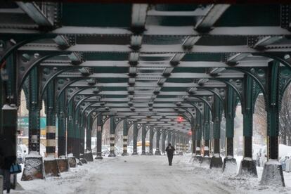 Las aerolíneas cancelaron cientos de vuelos el miércoles impidiendo viajar a muchos que regresaban a casa por Navidad. En la imagen, un hombre camina por una calle nevada en Nueva York.