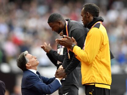 Sebastian Coe, tras imponer su medalla a Gatlin, con Bolt en el terecr escal&oacute;n del podio.