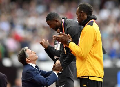 Sebastian Coe, tras imponer su medalla a Gatlin, con Bolt en el terecr escal&oacute;n del podio.