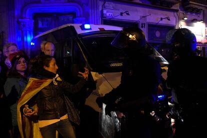 Una manifestante con una estelada habla con agentes antidisturbios durante la protesta en Barcelona. 