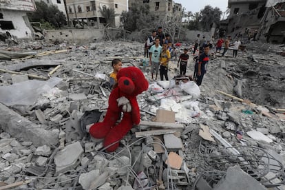 Un niño palestino trata de recuperar un oso de peluche de los escombros de una casa bombardeada en Deir al Balah, Gaza, este sábado.