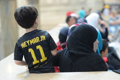 Uma criança síria com a camisa de Neymar junto a um grupo de refugiados na Estação Central de Milão, Itália.