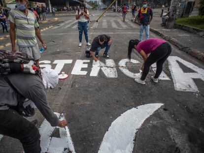 Jóvenes colombianos realizan pintadas de protesta en una avenida de la ciudad de Cali, el 8 de mayo.