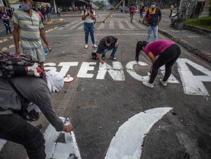 Jovens colombianos fazem pichações de protesto em uma avenida da cidade de Cali, Colômbia, em 8 de maio