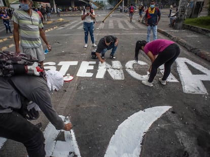 Jovens colombianos fazem pichações de protesto em uma avenida da cidade de Cali, Colômbia, em 8 de maio