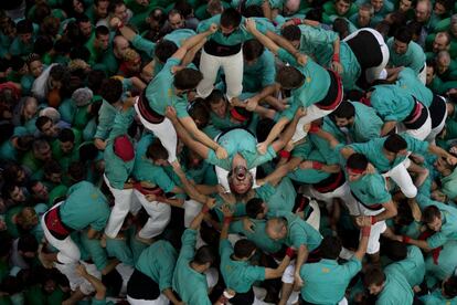 Miembros de los Castellers de Villafranca reaccionan con emoción tras conseguir descargar el castell.