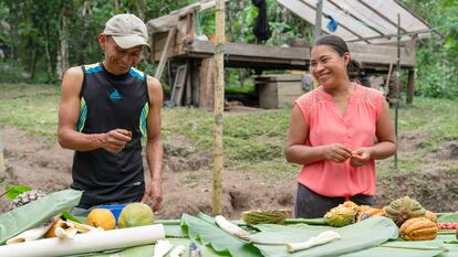 Dos campesinos extraen semillas de macambo, en Ecuador.