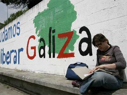 Una estudiante, al lado de una pintada nacionalista en el campus de Santiago de Compostela.