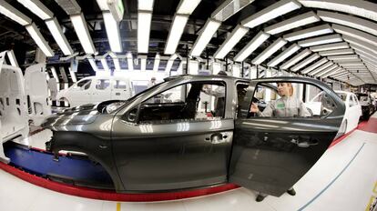 Una trabajadora revisa el arco de luces de un vehículo en una planta de PSA (Peugeot Citroën) de Vigo.