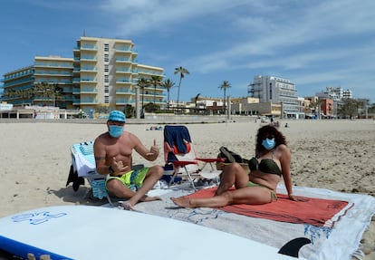 Bañistas con mascarilla, el martes en una playa de Mallorca.