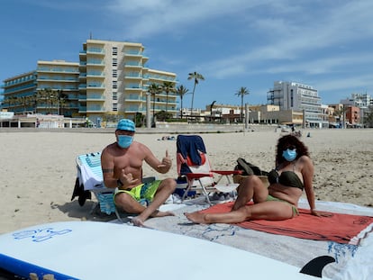 Bañistas con mascarilla, el martes en una playa de Mallorca.