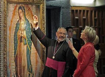 Hillary Clinton atiende las explicaciones del rector de la basílica de Guadalupe, Diego Monroy, en México.